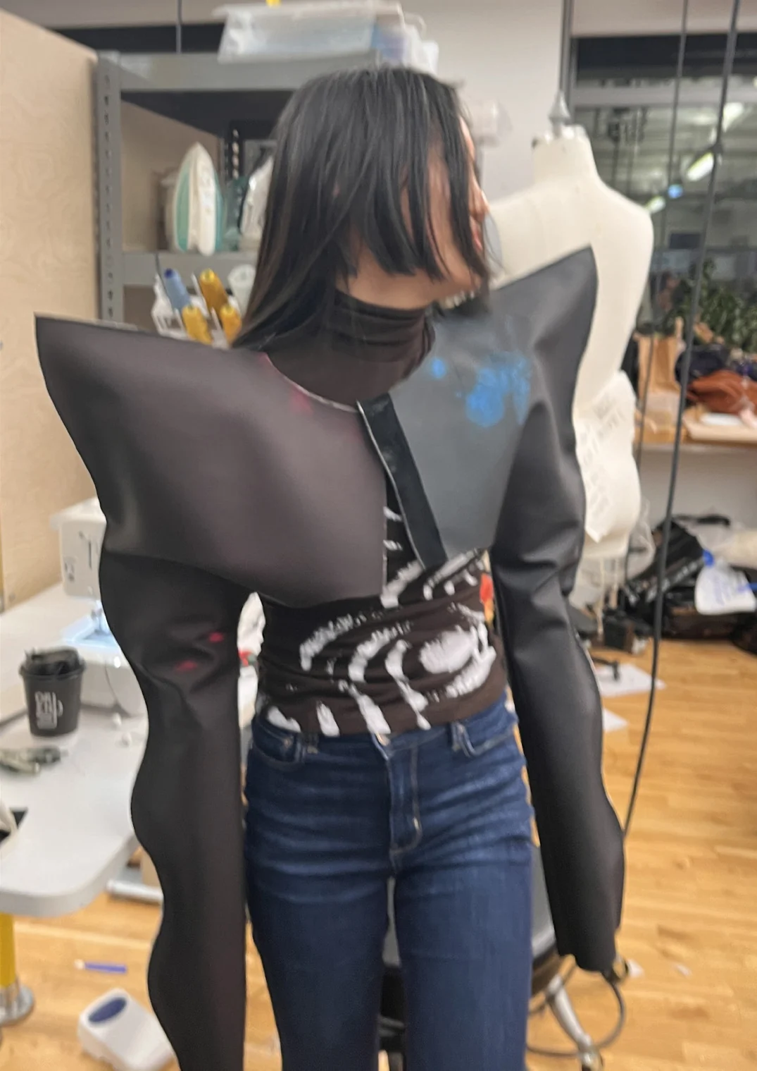 Duorfan wears the finished garment in the studio, showing its sculptural shoulders and wavy sides.