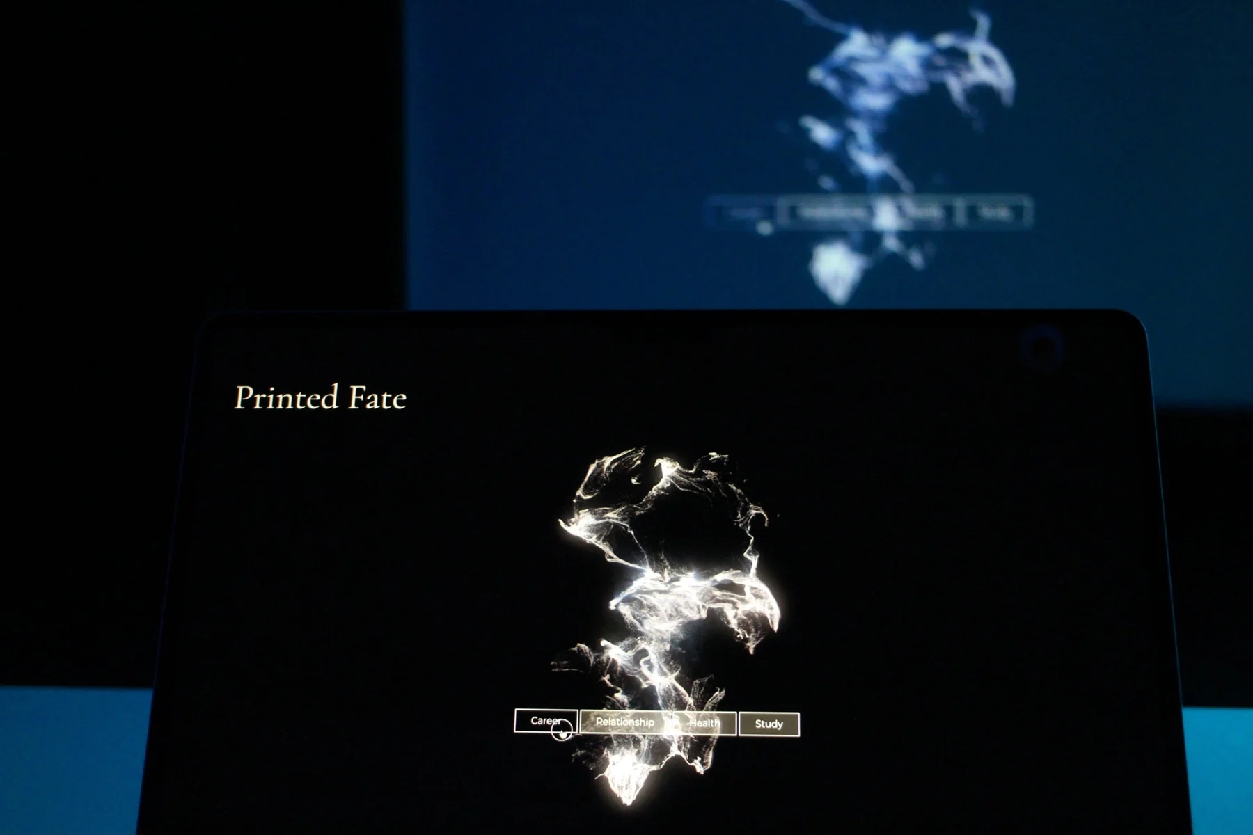 A laptop and a projection show luminous abstract visuals for Printed Fate.
